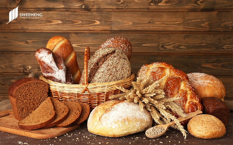 Selection of bread loaves and rolls on a table.