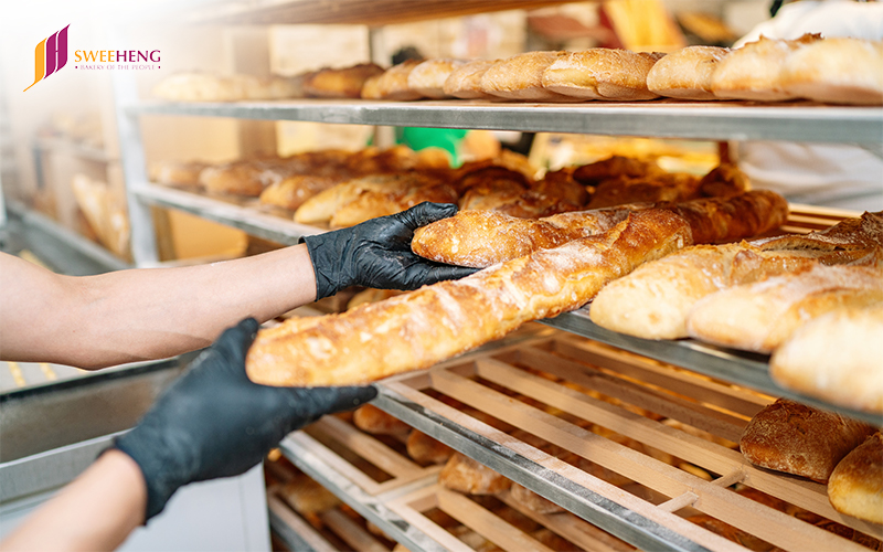 Man holding Bread in her hands for quality check