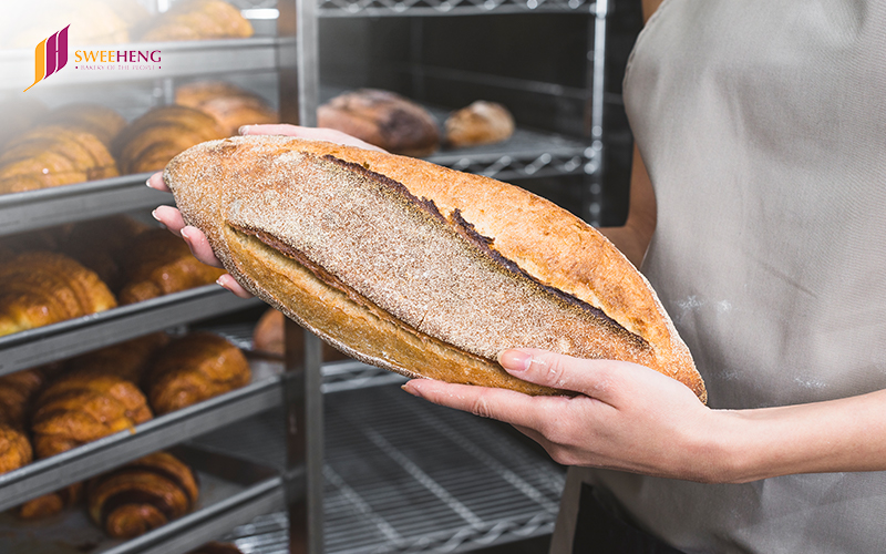 Woman holding Bread in her hands for quality check